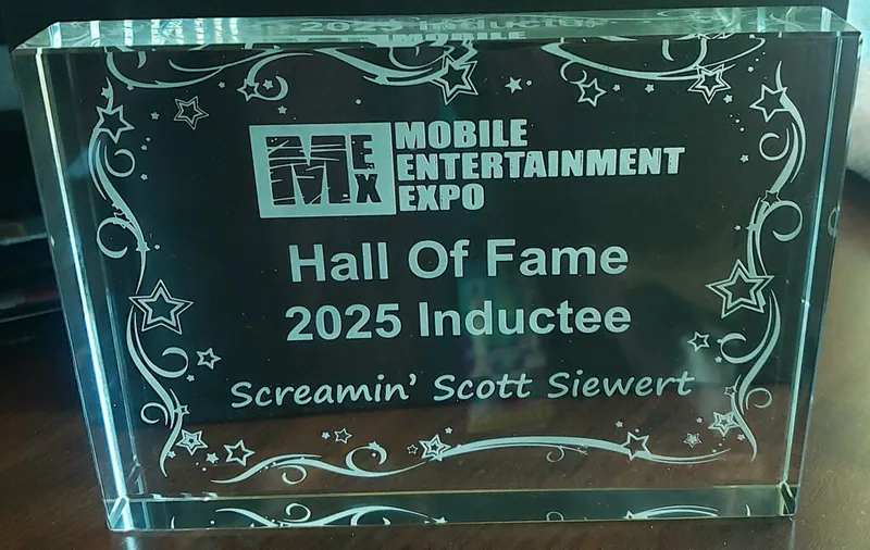 Glass Hall of Fame trophy reading Mobile Entertainment Expo 2025 Inductee Screamin Scott Siewert